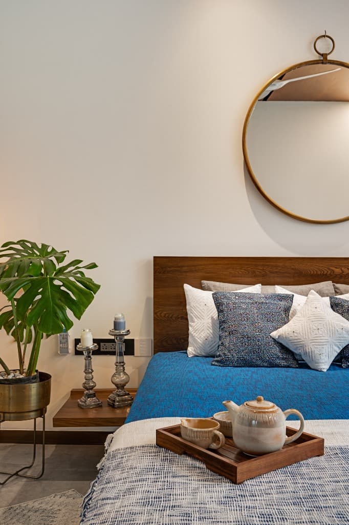 Artisanal tea service, hand-turned brass planter with monstera, and circular mirror detail in master suite