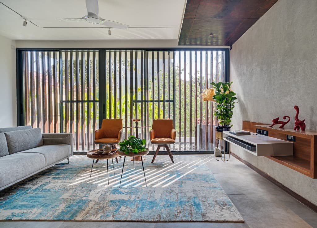Sun-drenched living salon with timber louvered shading casting kinetic light patterns