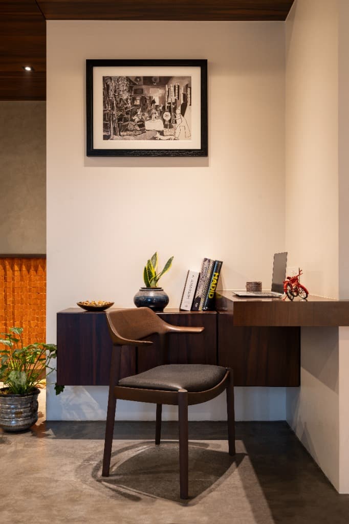 Cantilevered walnut study desk with ergonomic armchair, curated architectural monographs, and monochrome artwork