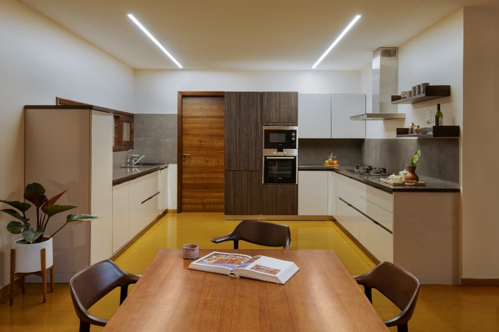 Contemporary modular chef's kitchen finished with warm ochre flooring and walnut millwork cabinetry