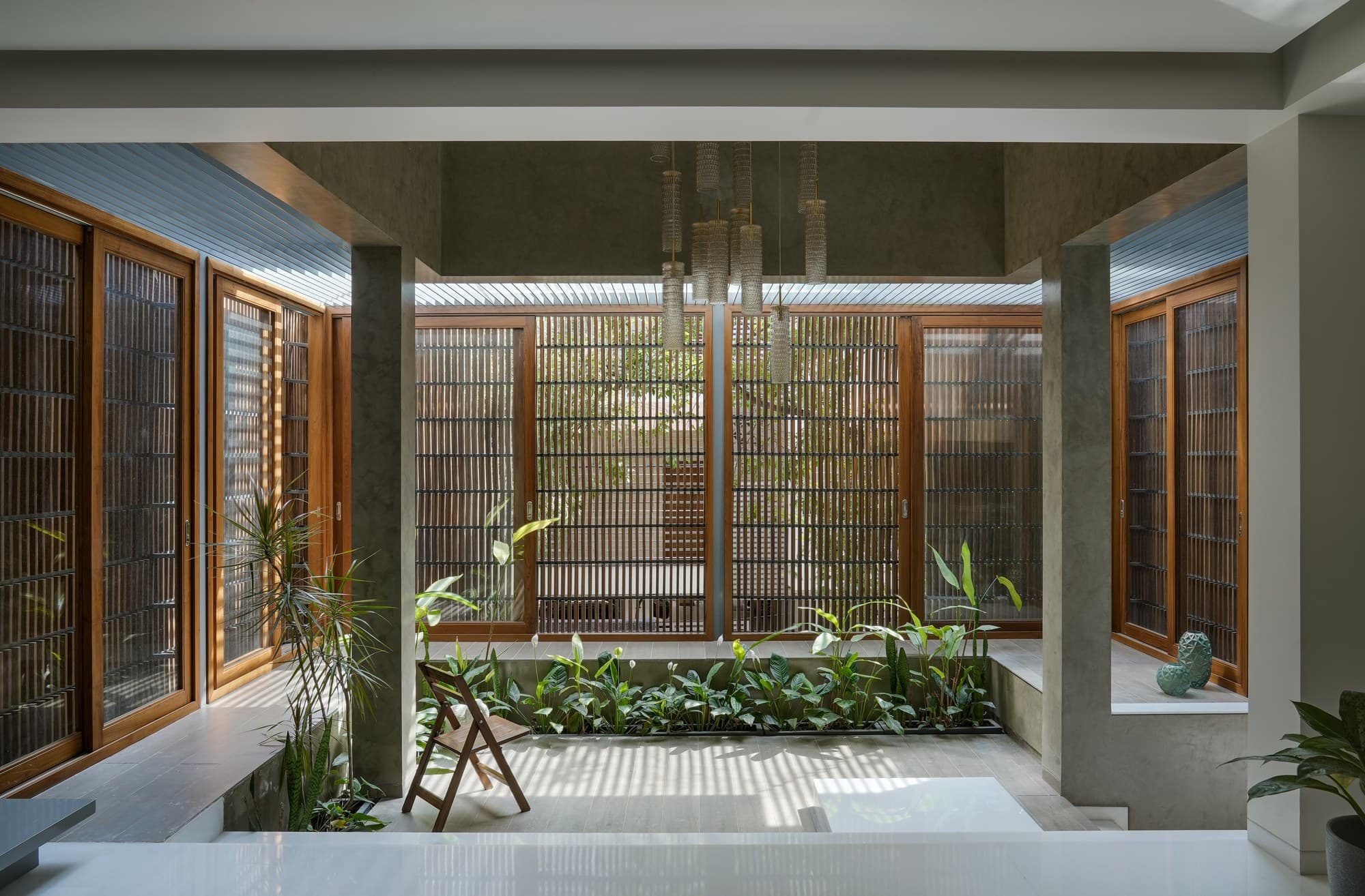 Internal courtyard with lush tropical planters and vertical timber screens