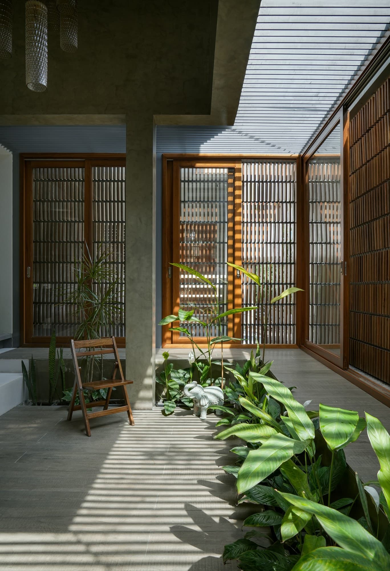 Internal courtyard with lush tropical planters and vertical timber screens