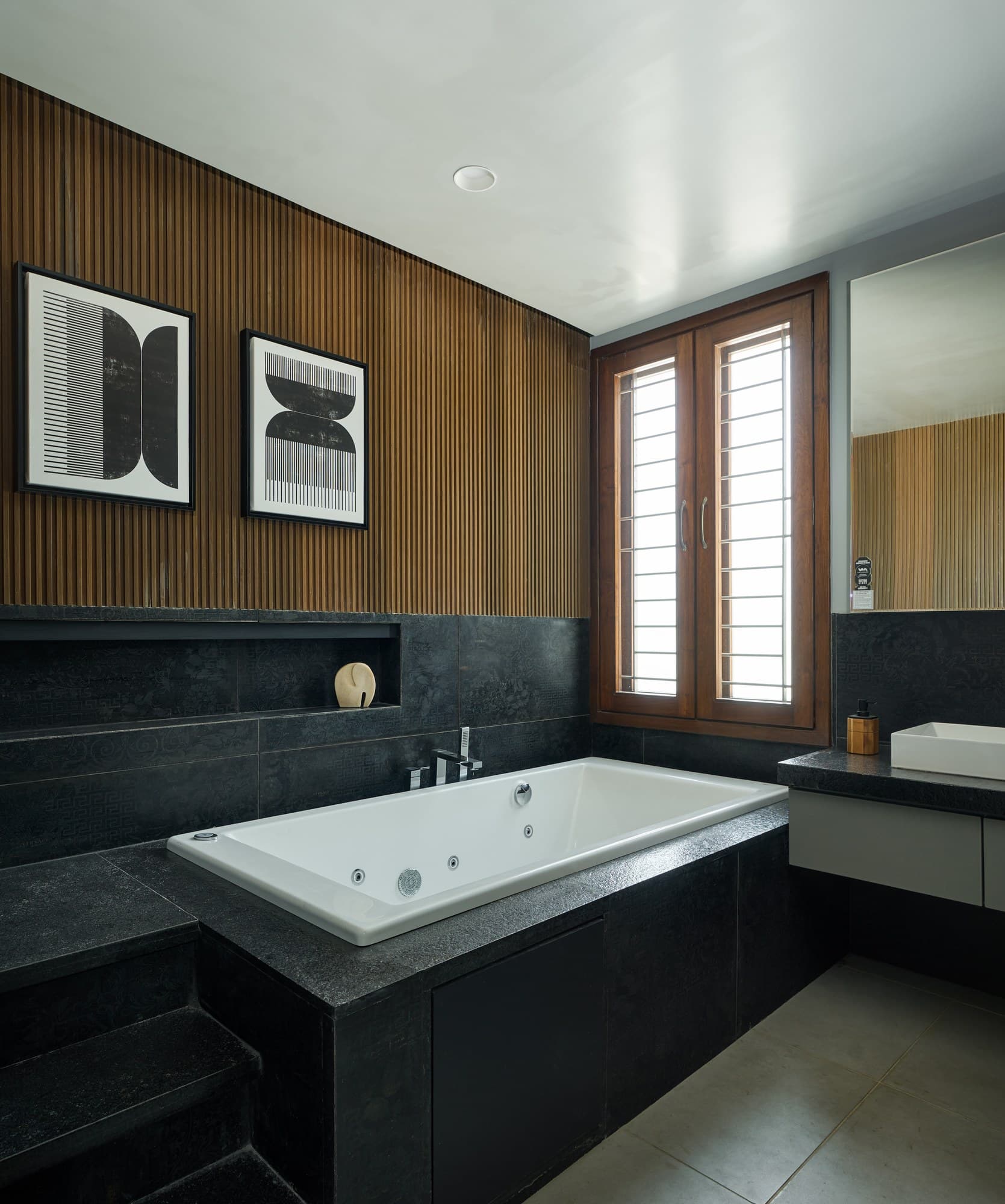 Ensuite bath sanctuary with sunken tub, black marble, and timber screen