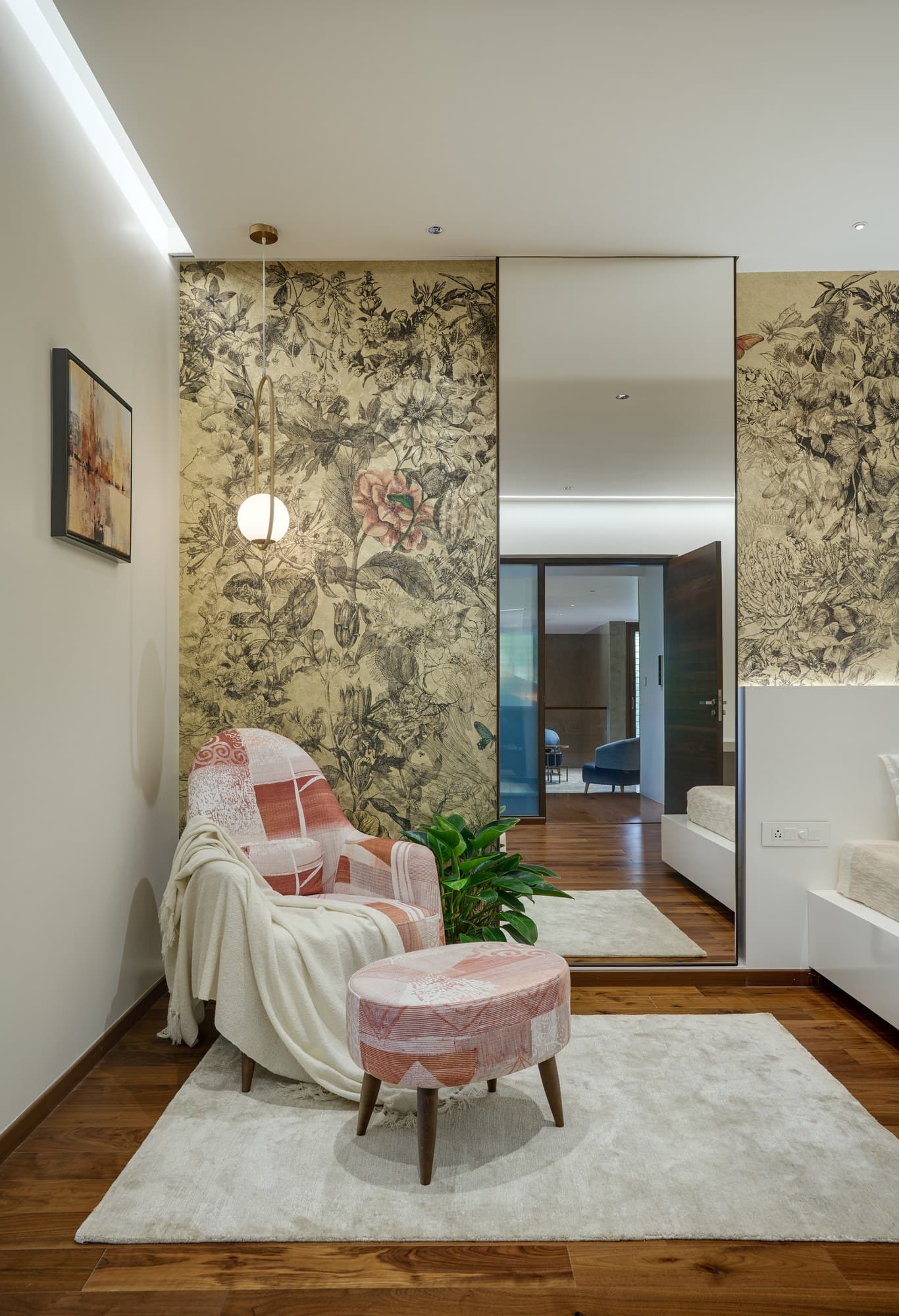Master bedroom reading lounge with plush terracotta armchair and full-height glazing