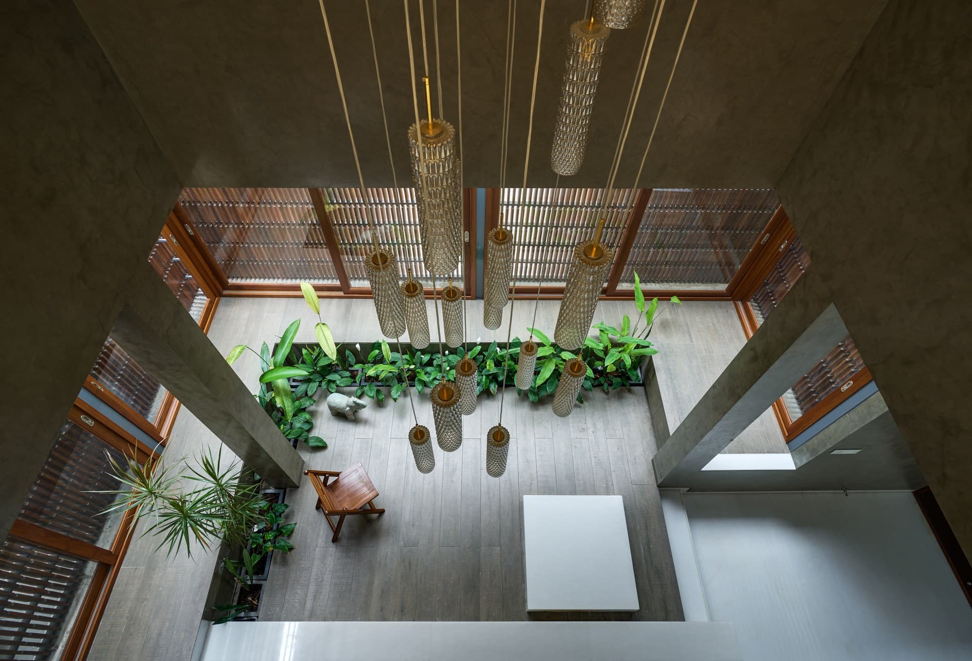 Aerial perspective looking down into the landscaped courtyard through glass pendants