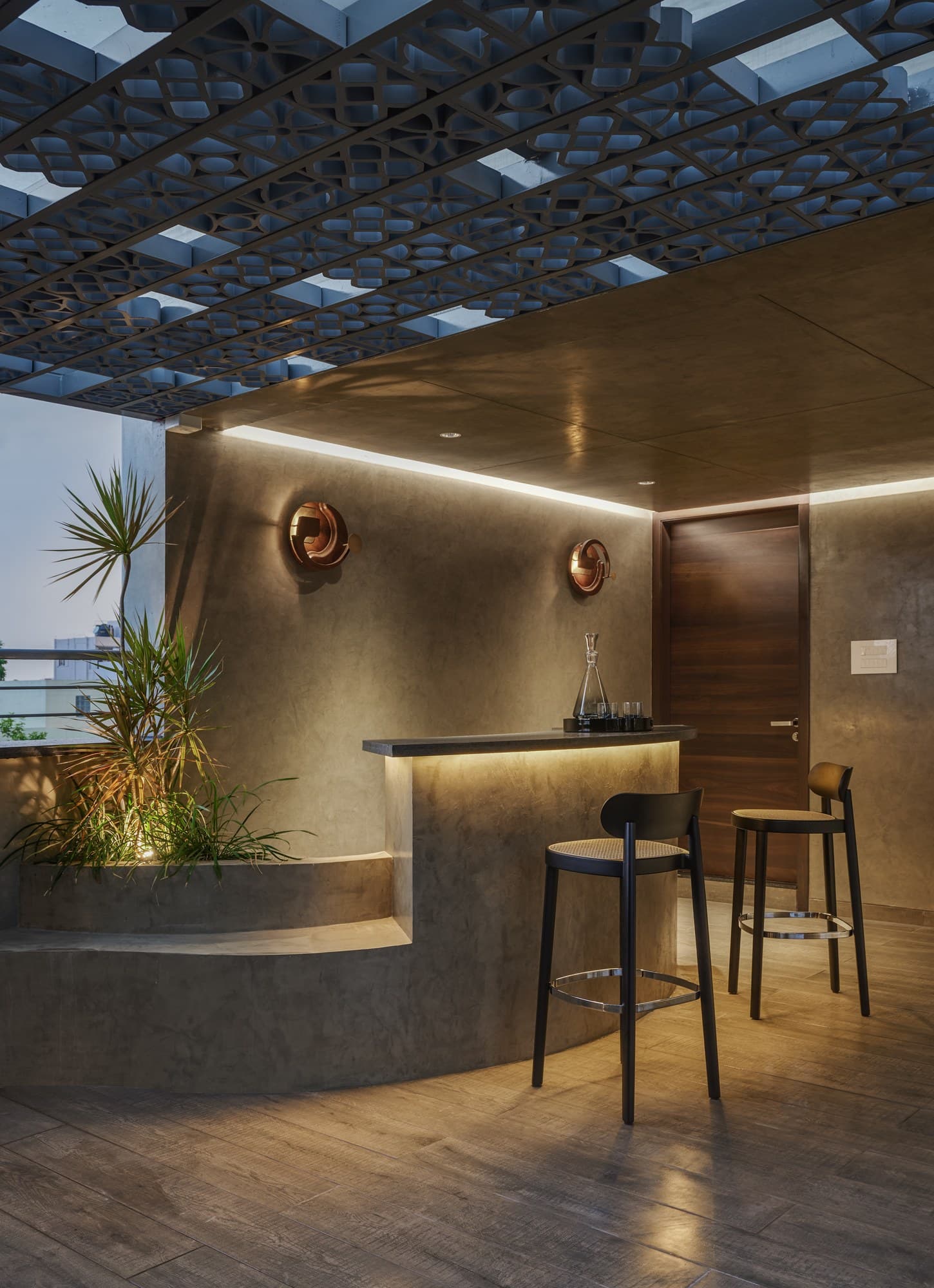 Terrace bar pavilion with curved micro-concrete plinth and geometric pergola