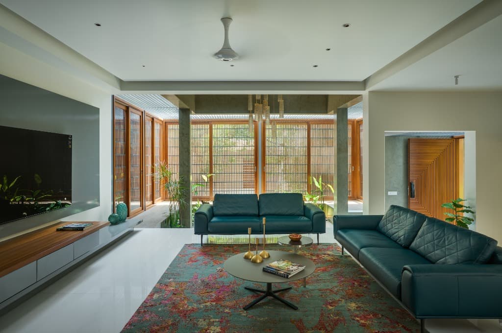 Sunken formal living lounge with bespoke floral carpet looking out towards internal court garden and slatted timber screens